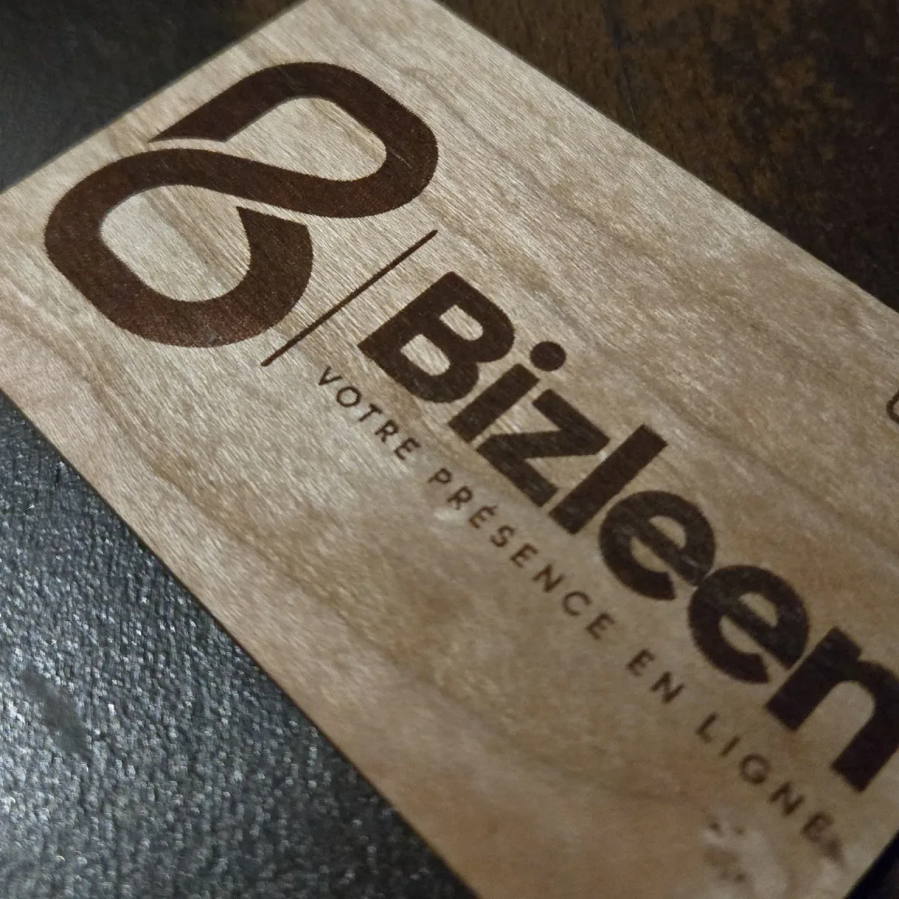 Détail de la gravure : le logo Bizleen et « Votre présence en ligne » brûlés dans le bois