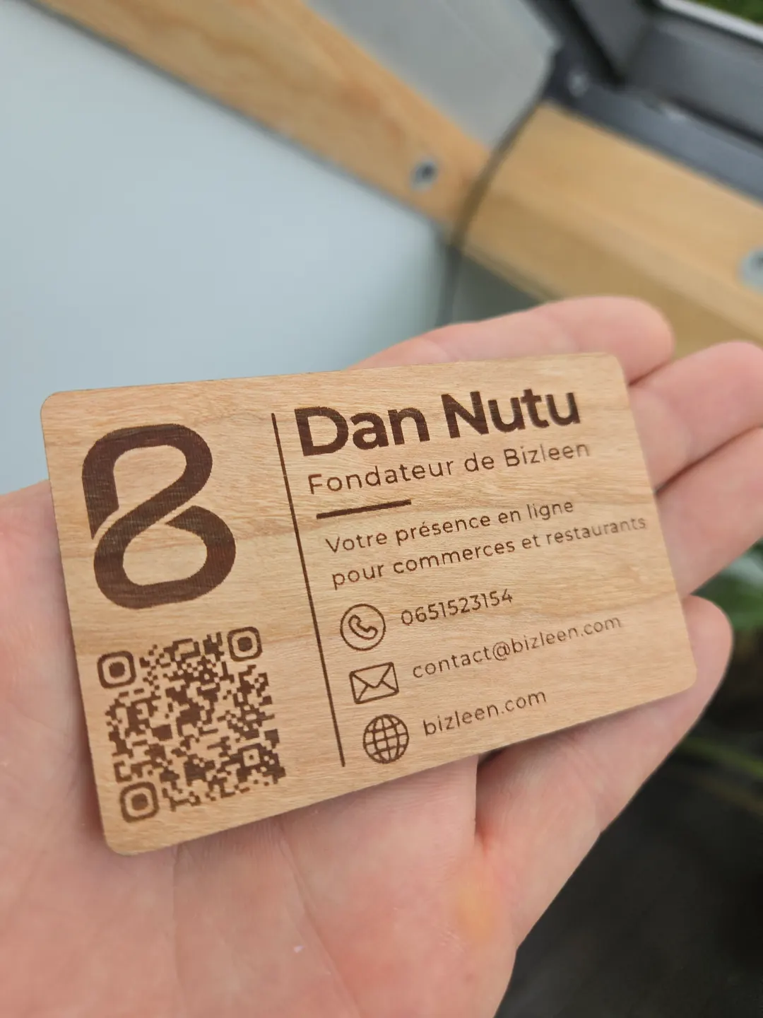 La même carte retournée : le nom de Dan, ses coordonnées et le QR code gravé